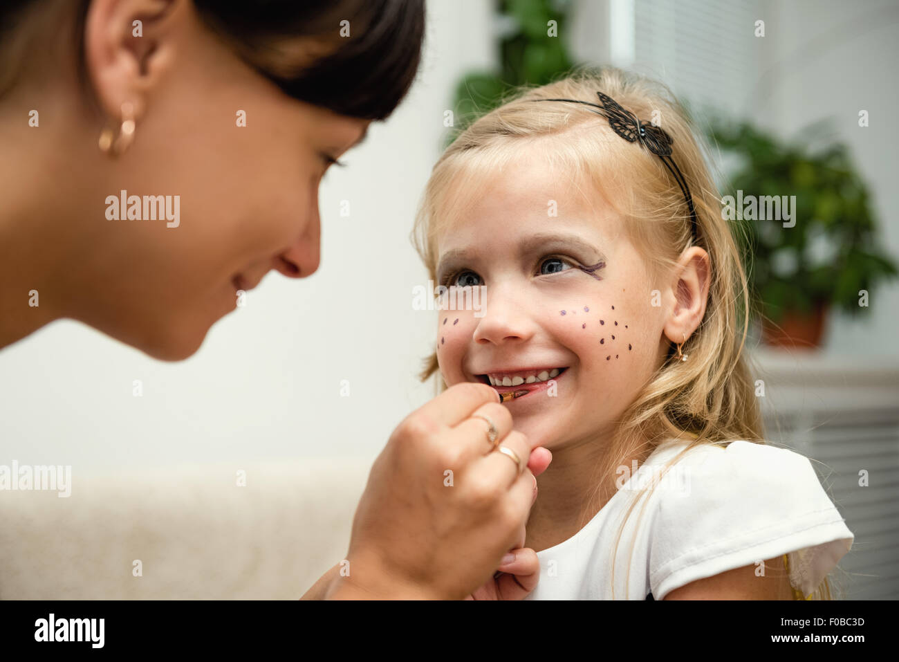 Femme peint le visage d'un enfant pour les vacances Banque D'Images