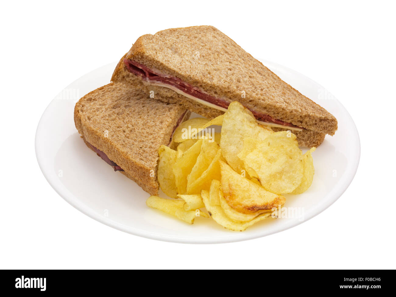 Un sandwich au rôti de bœuf avec du fromage blanc et la mayonnaise et croustilles de pommes de terre sur une plaque blanche. Banque D'Images