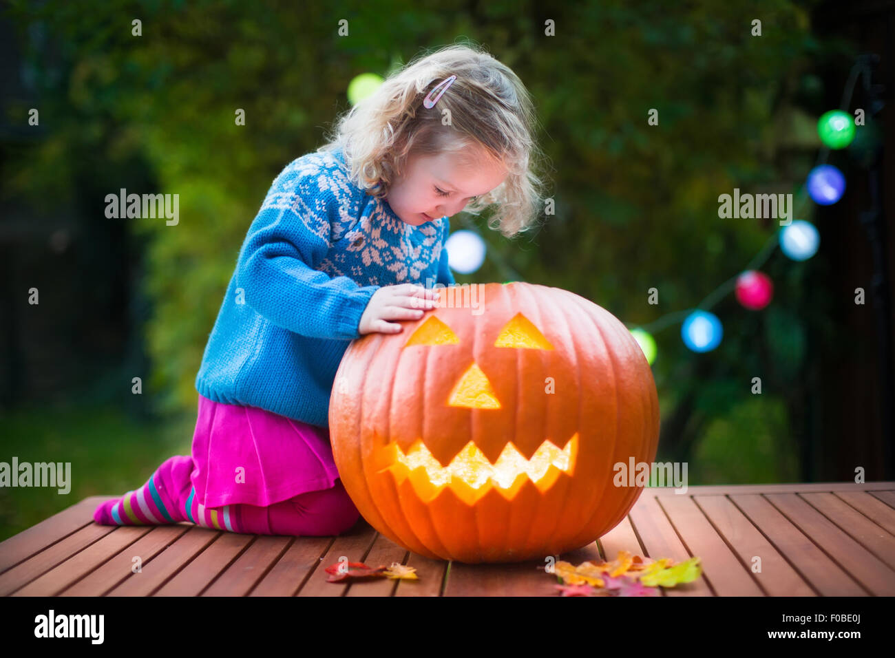Petite fille à l'Halloween Pumpkin carving. Habillé tour ou traitement de l'enfant. Kids trick ou traiter. Enfant en costume Banque D'Images