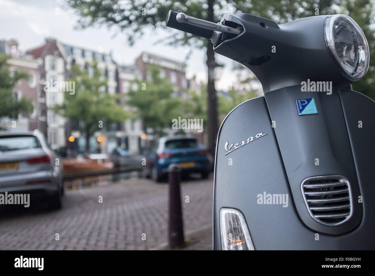 Un Vespa cyclomoteur dans les rues d'Amsterdam par un canal Banque D'Images
