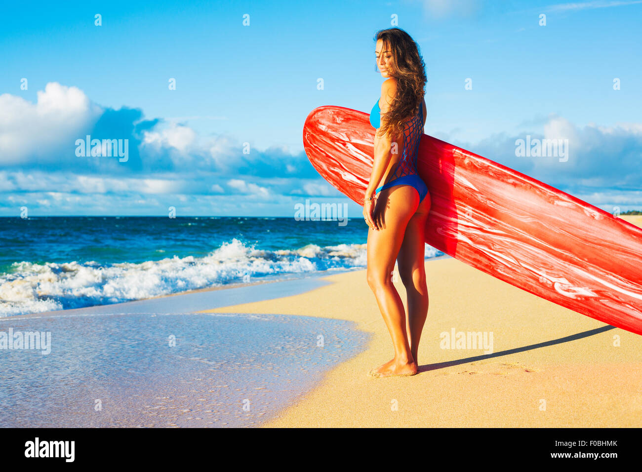 Beau Surfer Girl sur la plage au coucher du soleil. Style de vie en plein air d'été. Banque D'Images