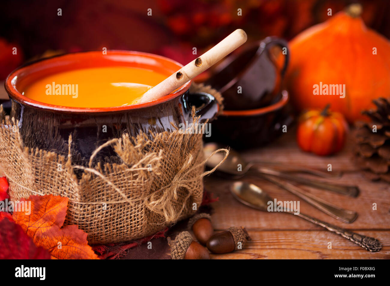 Un pot de crème maison soupe de potiron sur une table rustique avec des décorations d'automne. Banque D'Images