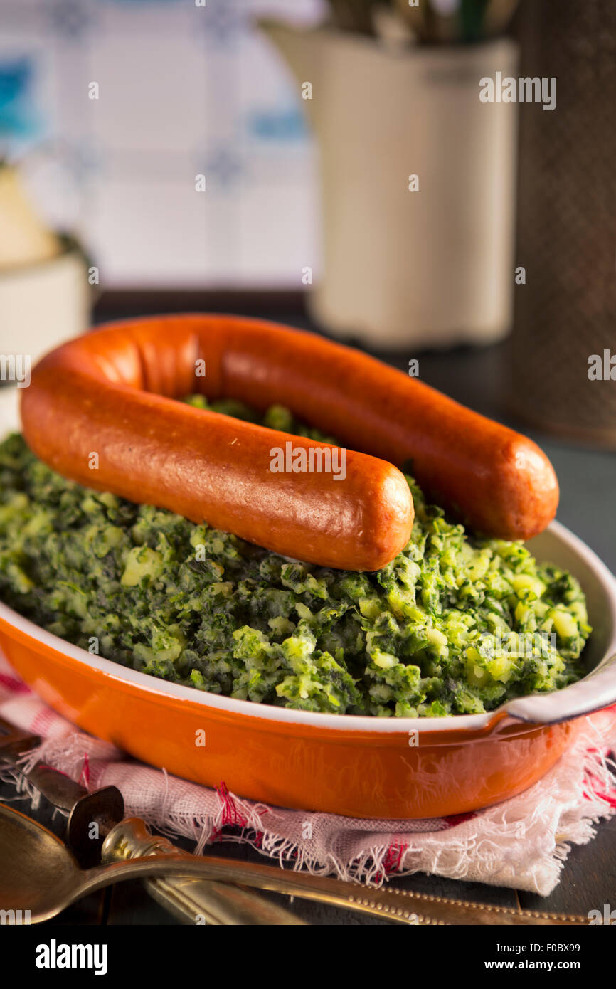 Une cuisine rustique avec un plat avec 'Boerenkool rencontré pire' ou le chou frisé avec saucisse fumée, un repas traditionnel néerlandais. Banque D'Images