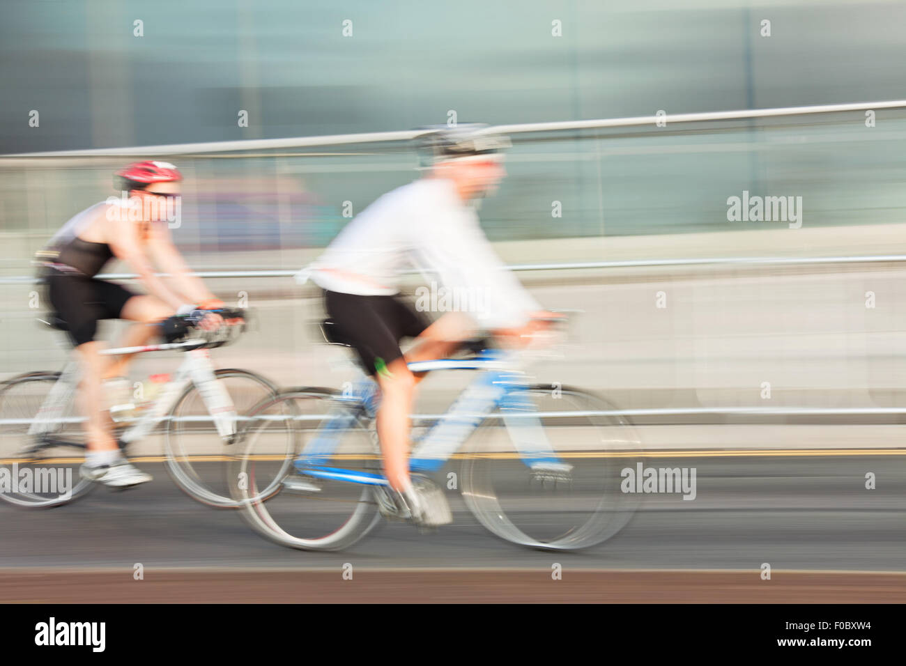 Deux athlètes équitation vélo dans la ville, blurred motion. Banque D'Images