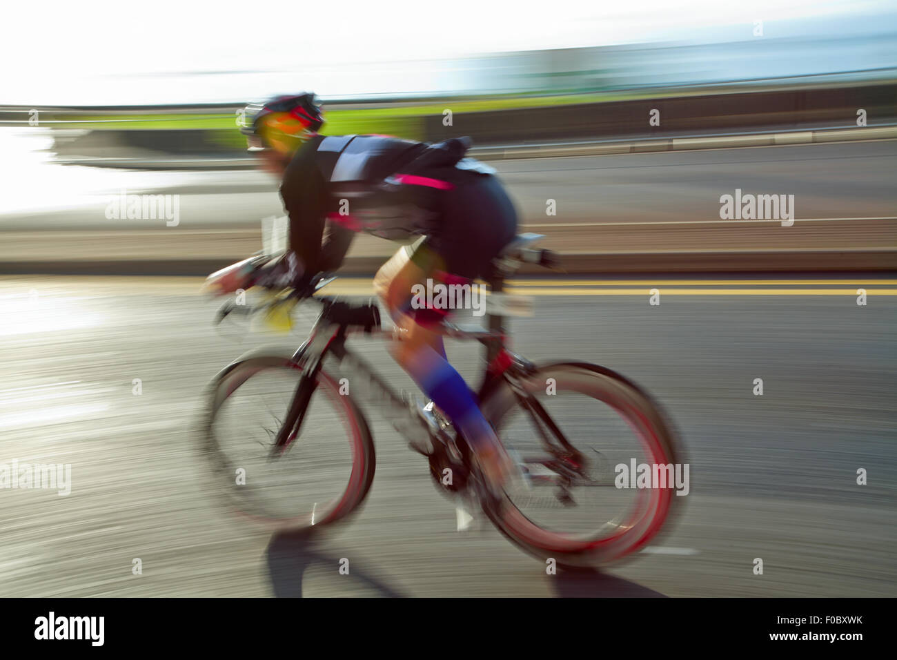 Équitation athlète vélo à journée ensoleillée sur la route côtière, blurred motion Banque D'Images