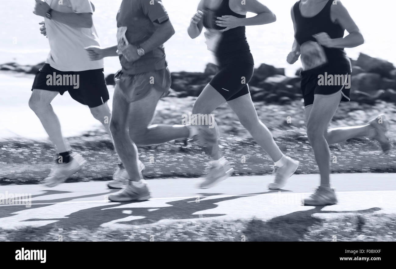 Groupe de coureurs en compétition dans la course sur route côtière. Blurred motion Banque D'Images