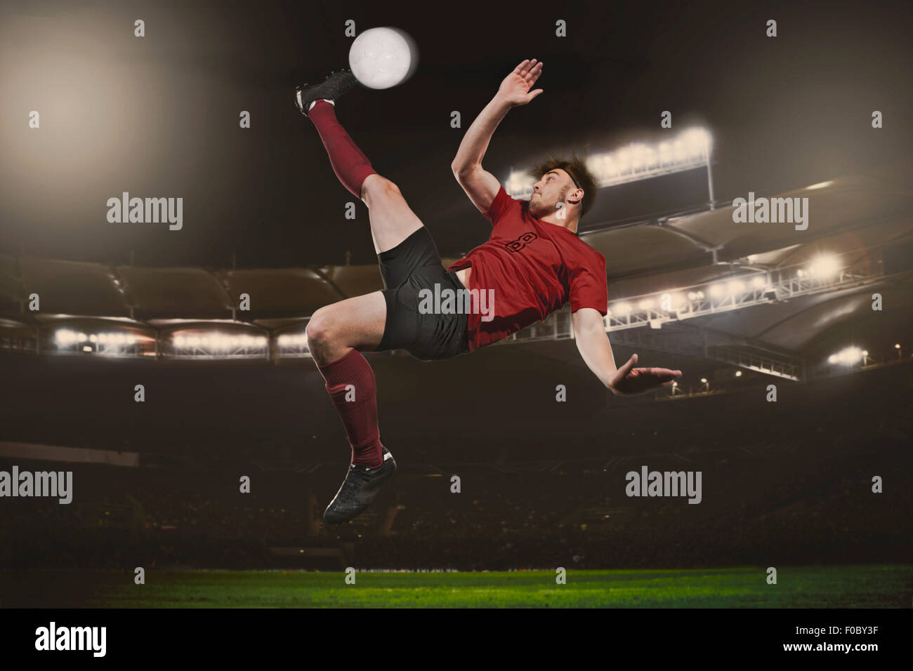 Toute la longueur de soccer player kicking ball on field Banque D'Images
