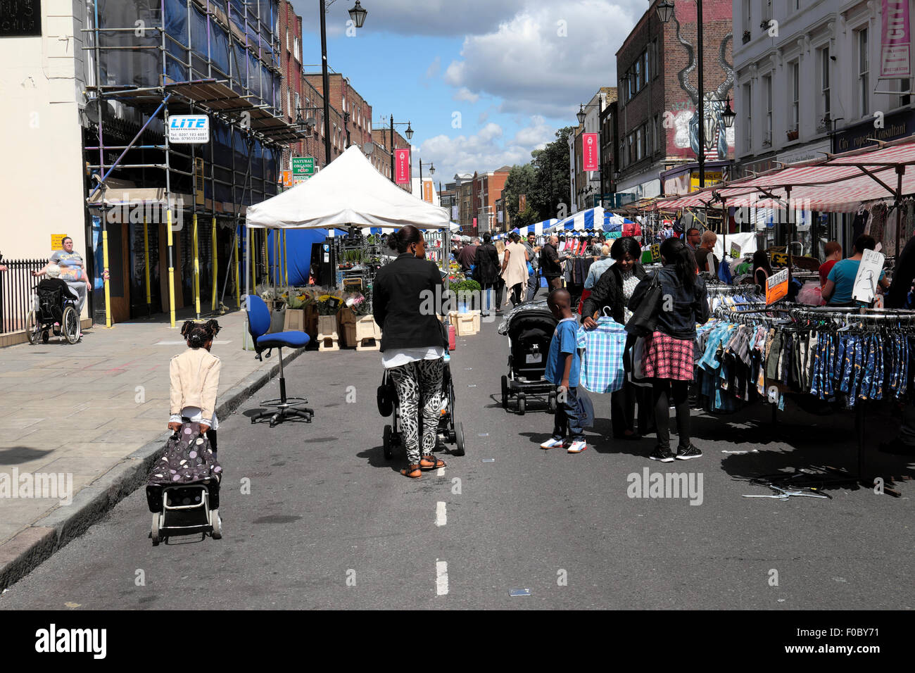 La mère pousse une poussette vue arrière et l'enfant avec le shopping Trolley shoppers dans les stands du marché de Hoxton Street à l'est LONDRES, ROYAUME-UNI KATHY DEWITT Banque D'Images
