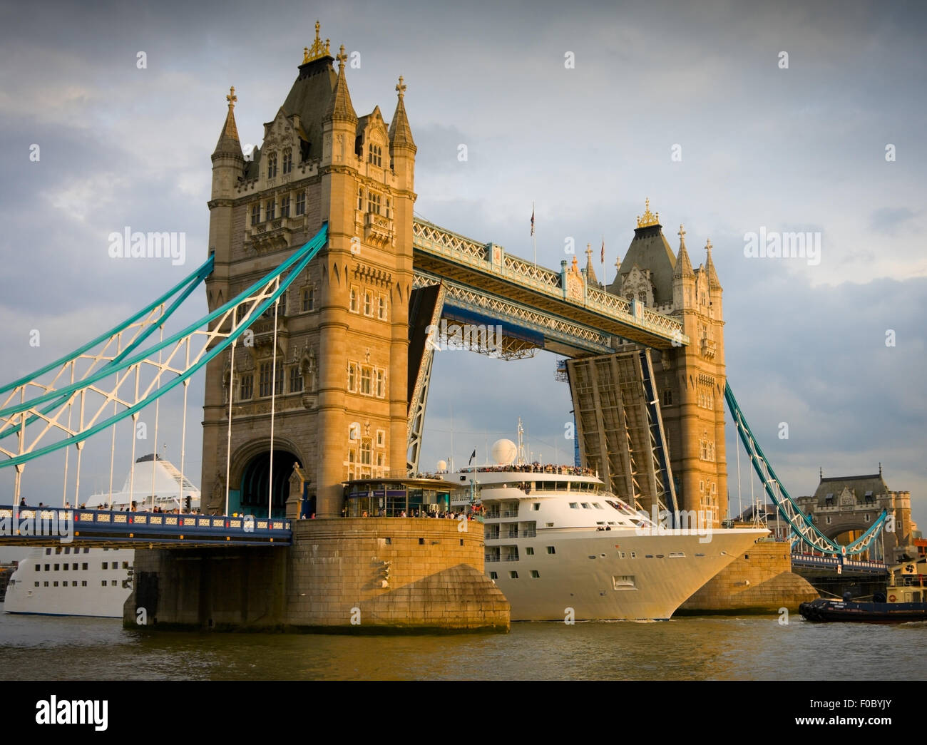 Grand navire de croisière blanche passant du London Tower Bridge au coucher du soleil Banque D'Images