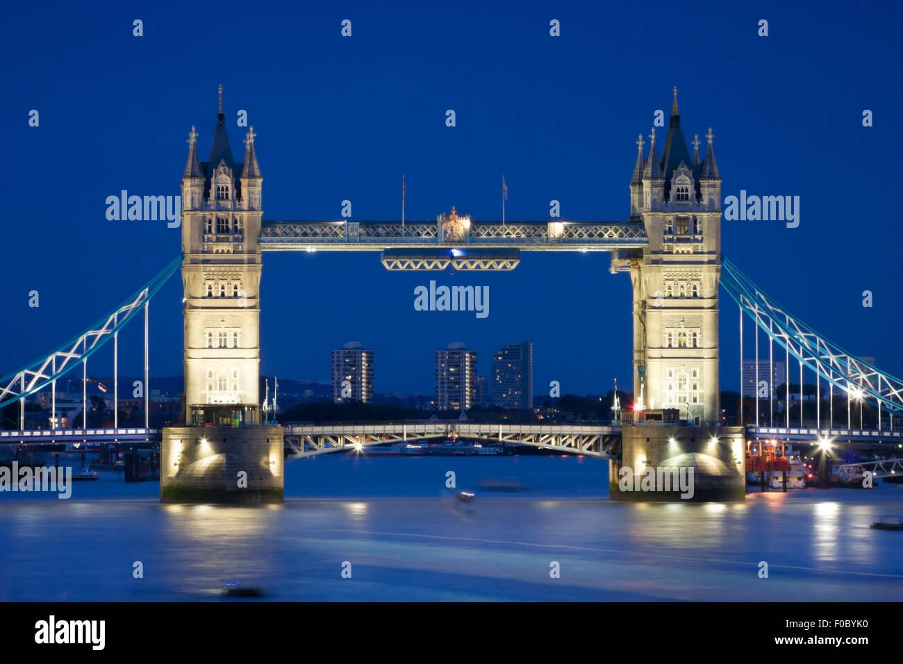 La London Tower Bridge illuminé la nuit de temps et de réflexions dans l'eau Banque D'Images