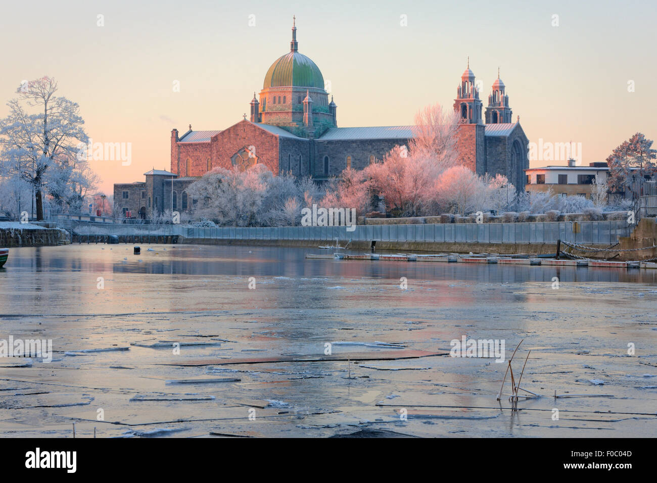 La Cathédrale de Galway en première sunlights et couverte de glace de la rivière Corrib au froid matin d'hiver Banque D'Images