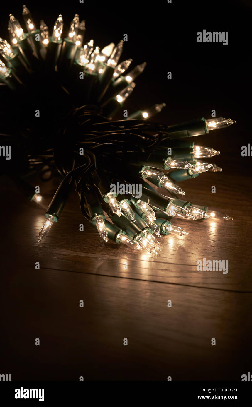 Les lumières d'arbre de Noël traditionnel couché sur un plancher en bois. Banque D'Images