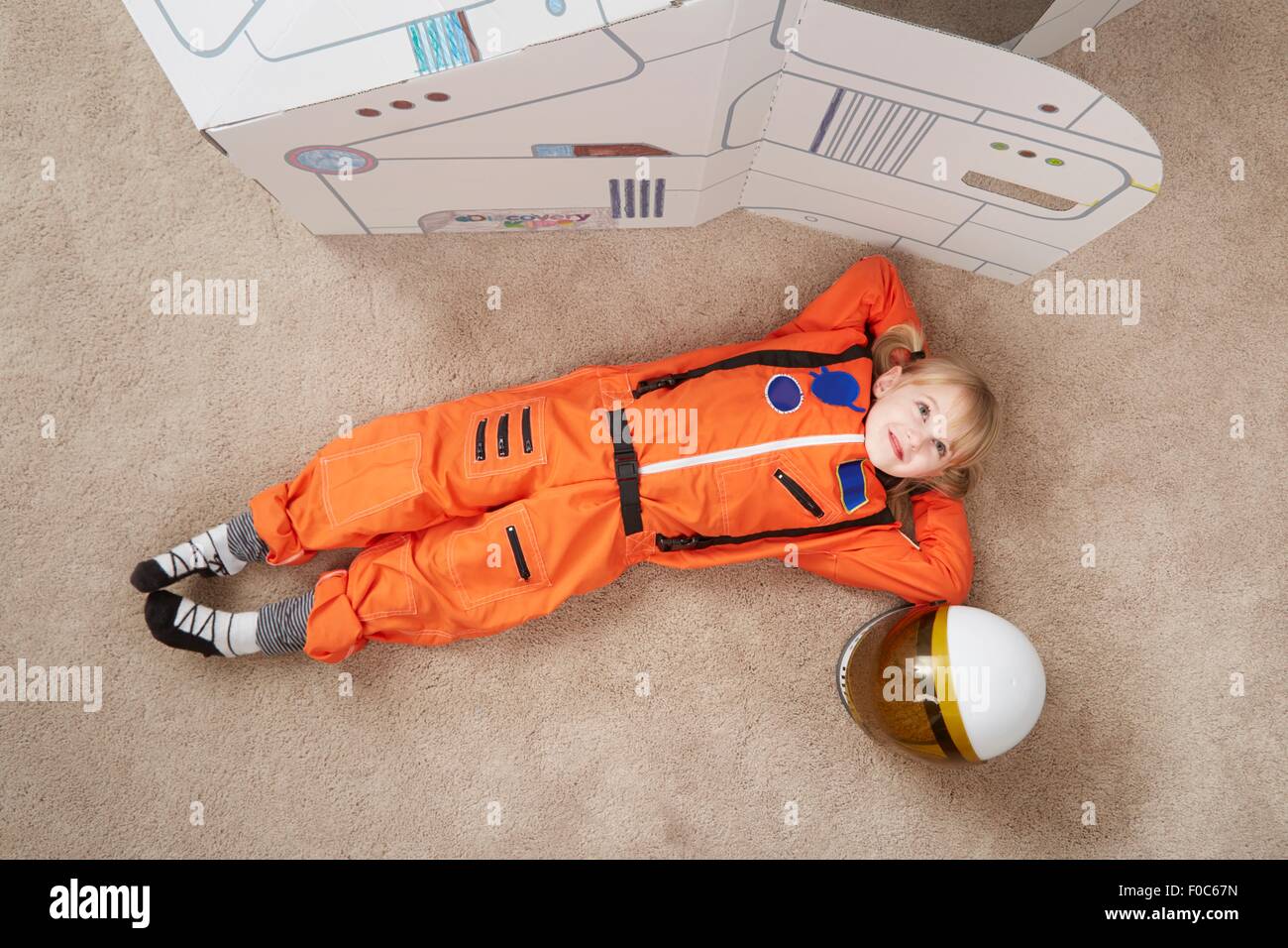 Jeune fille jouant, portant tenue d'astronaute, couché à côté de vaisseau  en carton, elevated view Photo Stock - Alamy