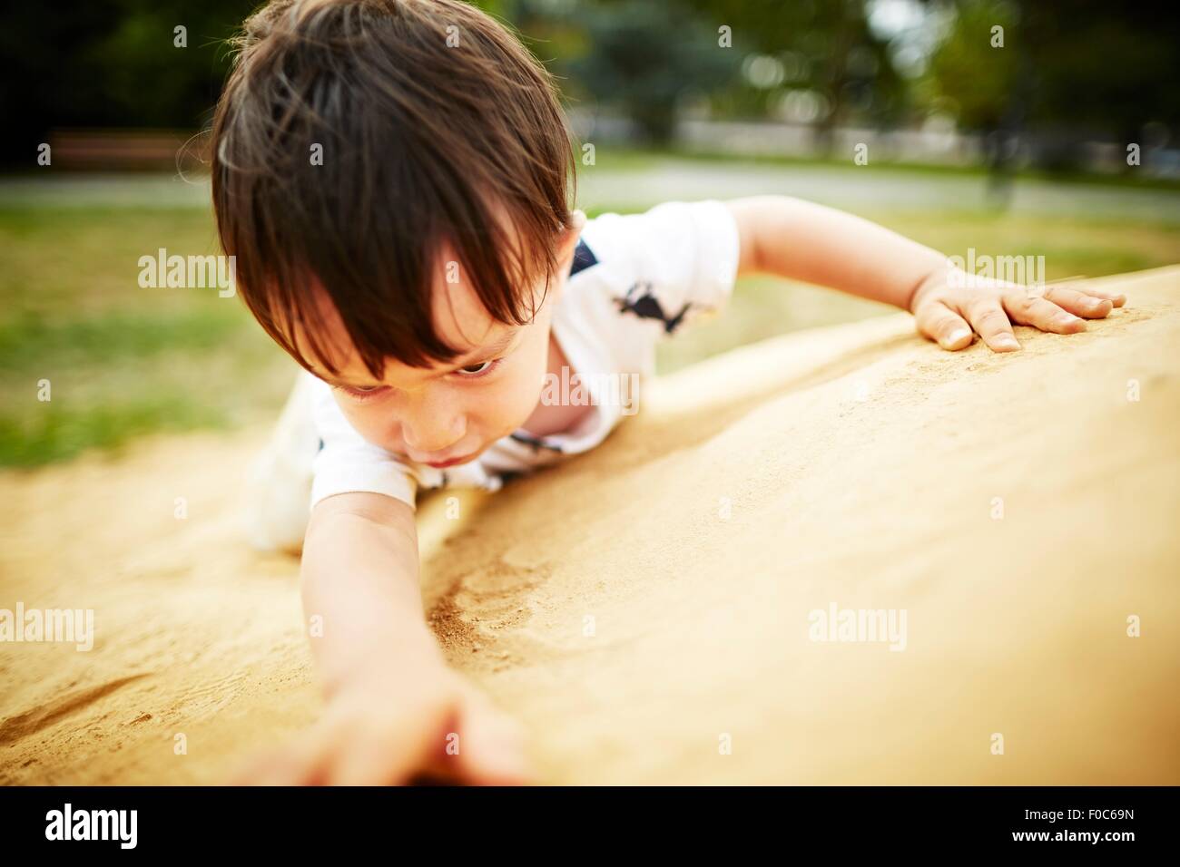 Close up of boy climbing a sand rock Banque D'Images
