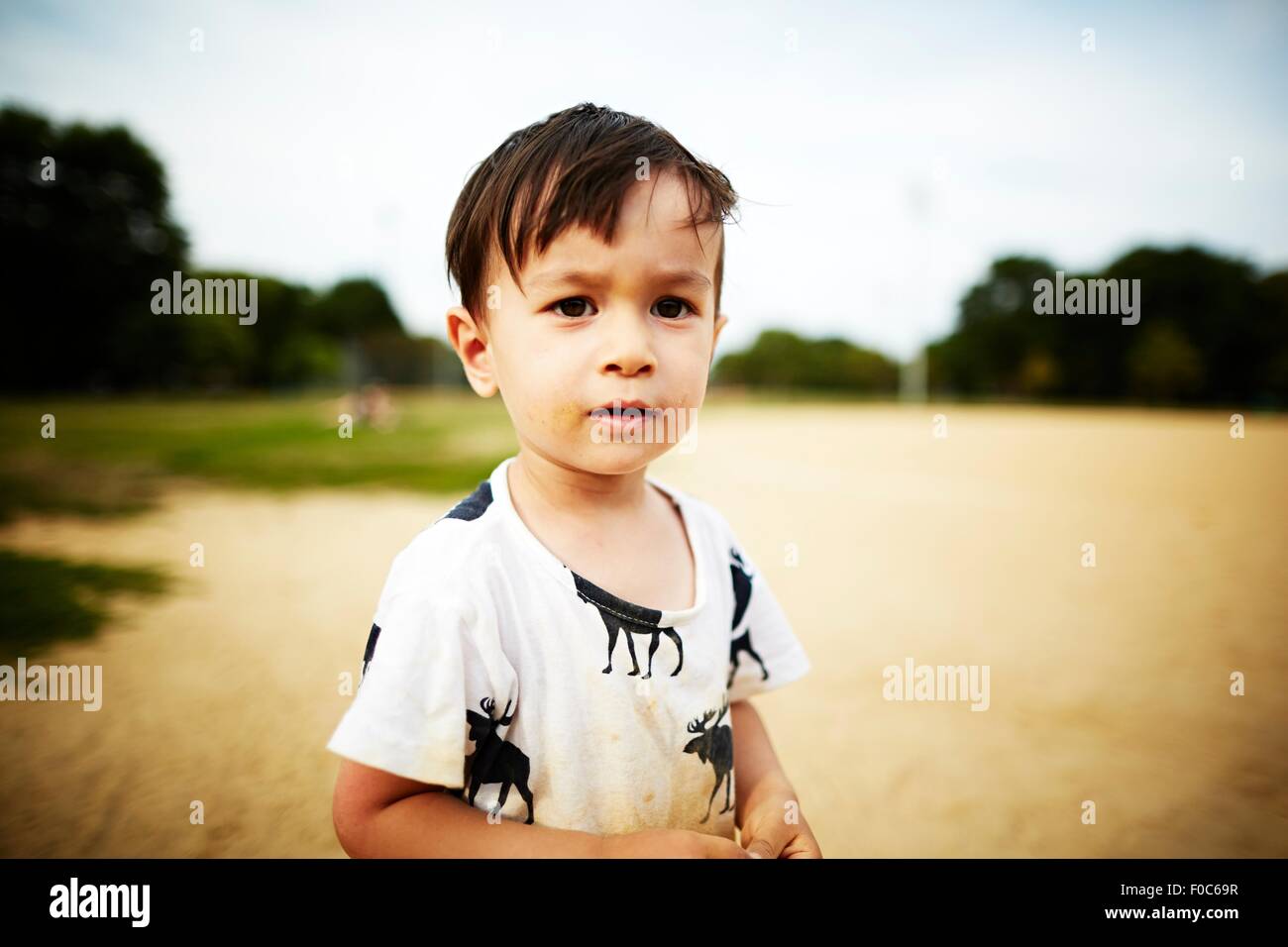 Portrait of boy standing in sand looking at camera Banque D'Images