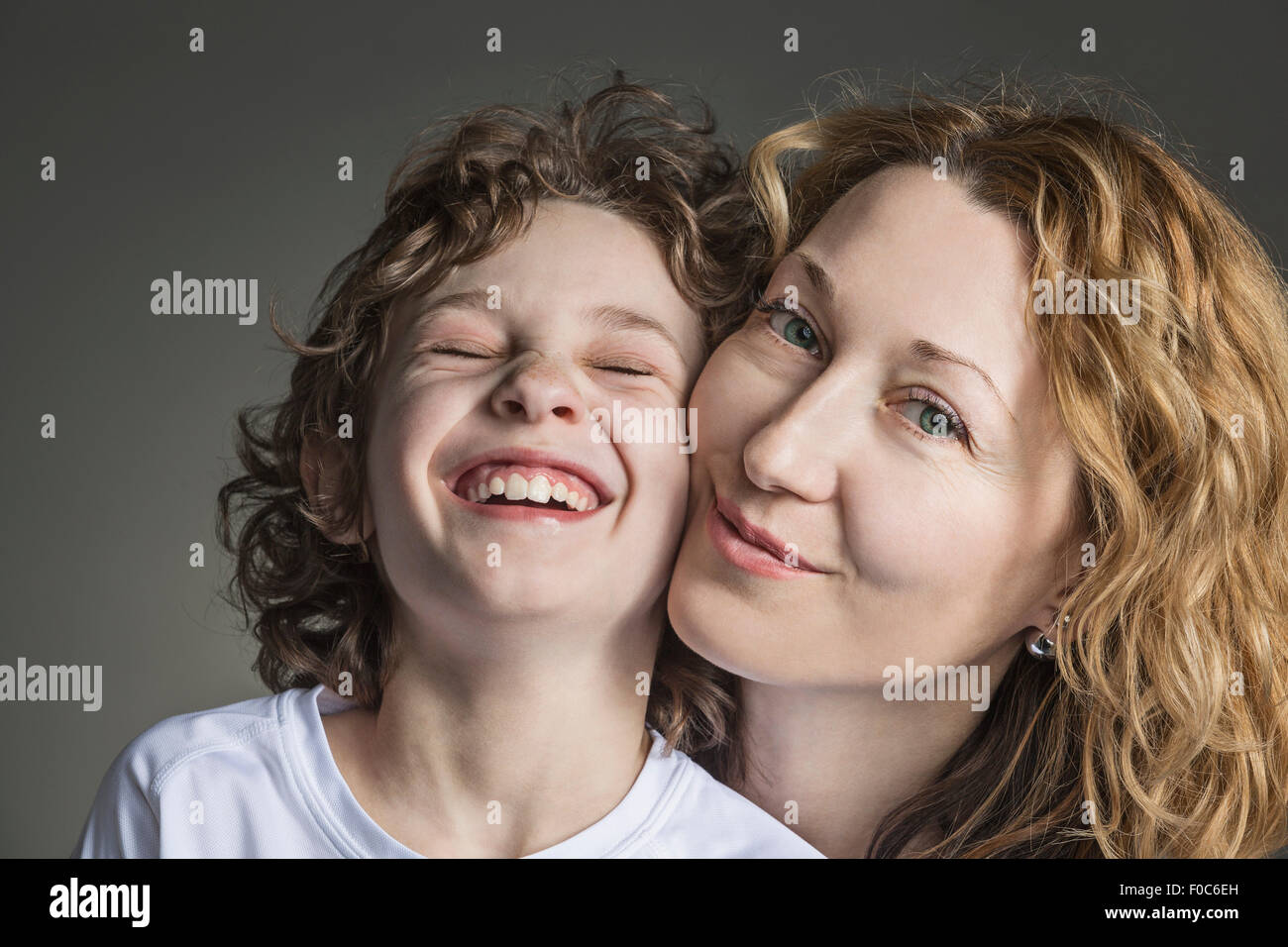 Close-up portrait de mère avec fils joyeux sur fond gris Banque D'Images