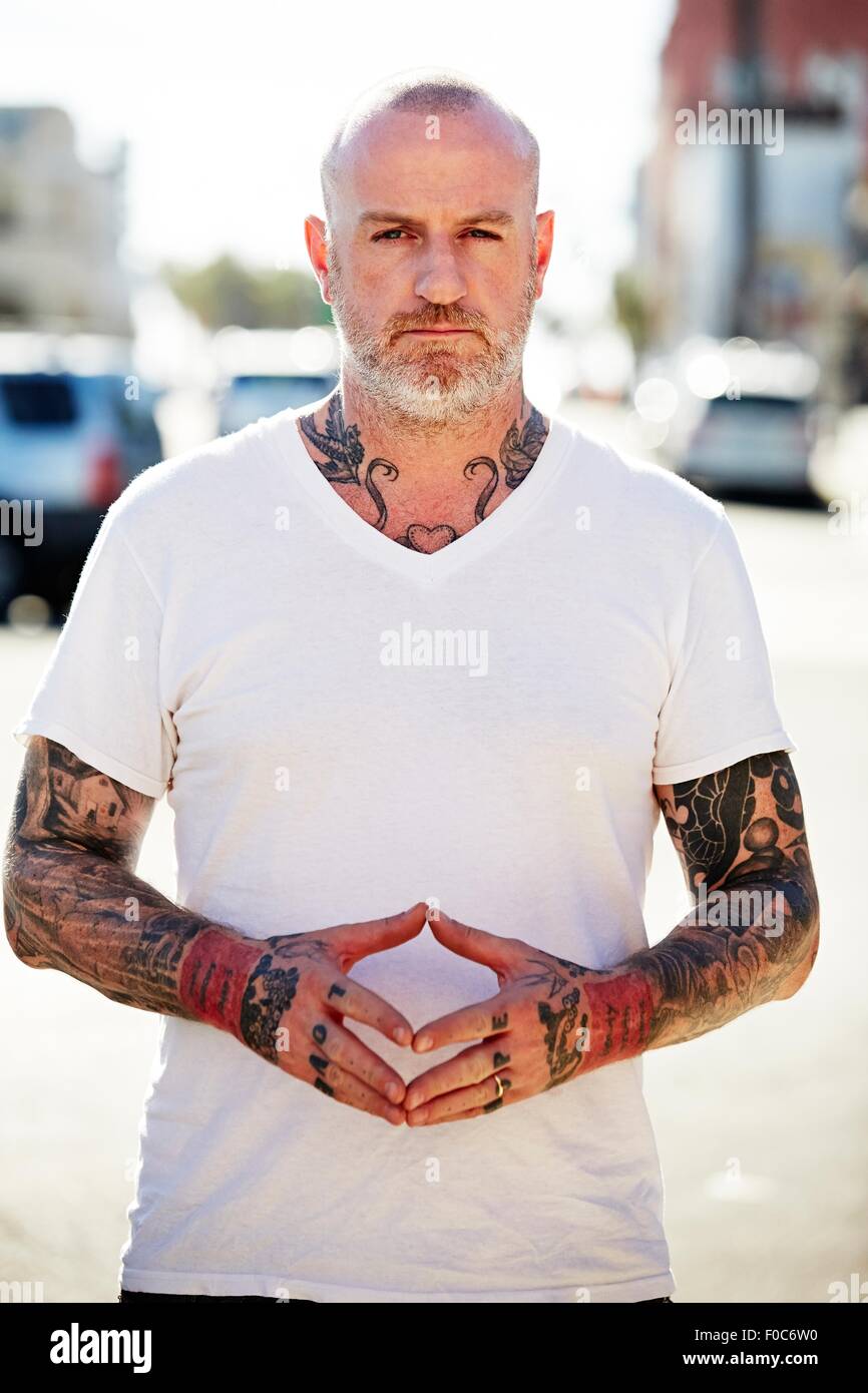 Homme mûr avec des tatouages sur les bras et le cou Banque D'Images