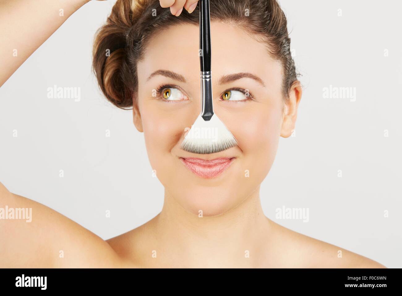 Jeune femme tenant une brosse de maquillage Banque D'Images
