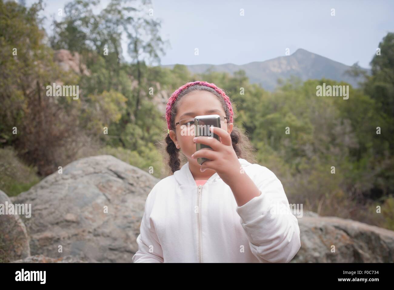 Jeune fille en milieu rural, using smartphone Banque D'Images