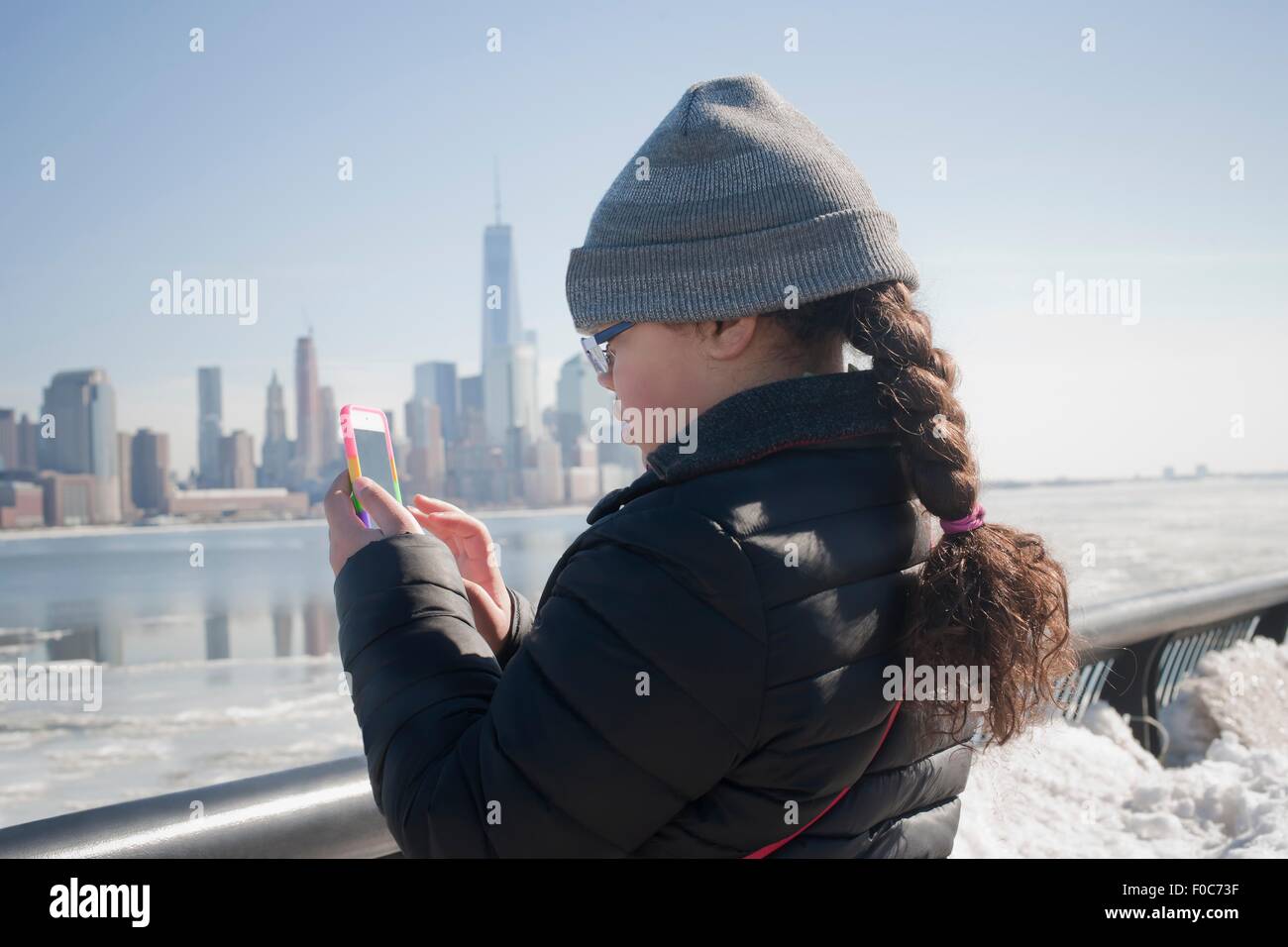 Young Girl taking photograph of skyline en utilisant smartphone, New York, NY, USA Banque D'Images