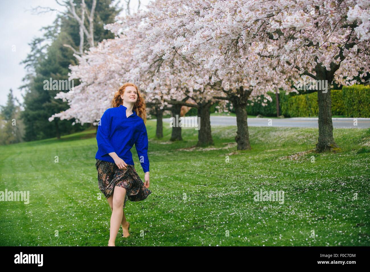 Jeune femme danser pieds nus dans le parc au printemps Banque D'Images