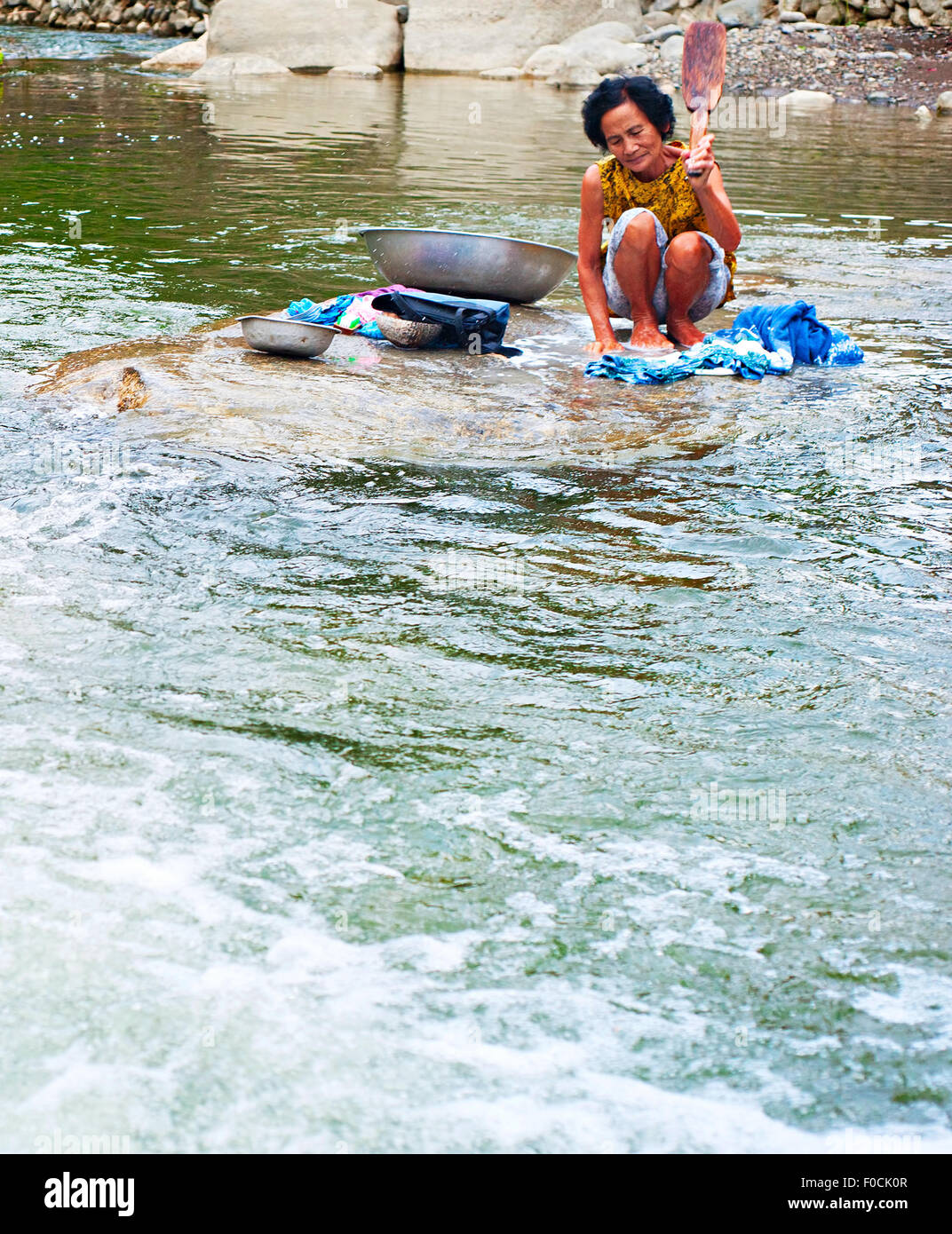 Philippines femme laver les vêtements sur la rivière en mode traditionnel. Banque D'Images