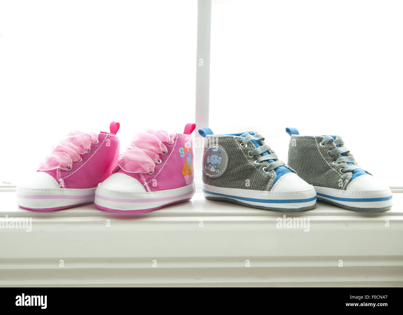 Deux paires de chaussures de bébé, un rose et un bleu/gris. Anticiper la  naissance d'un garçon et fille Photo Stock - Alamy