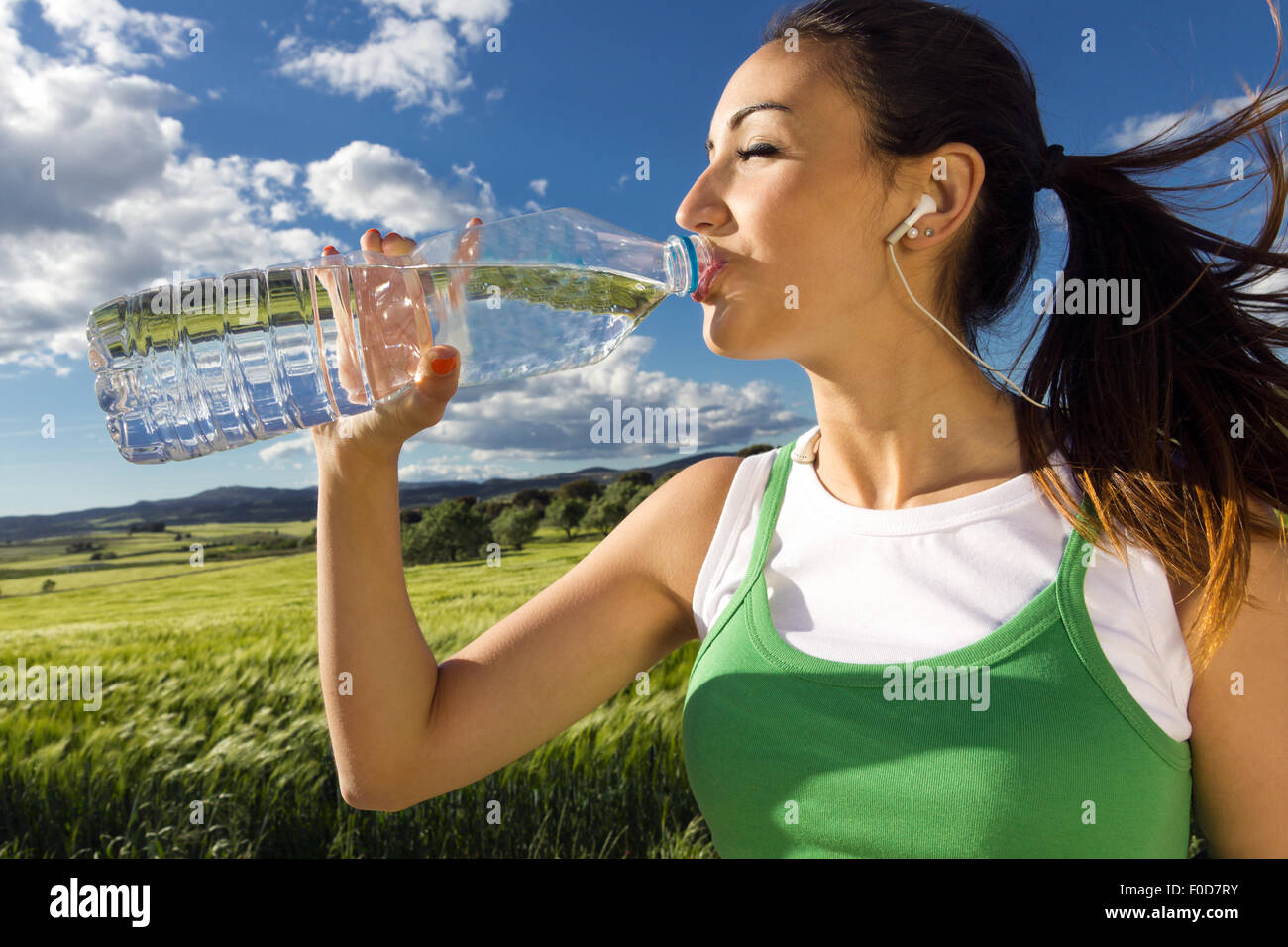 L'eau potable femme après les activités sportives dans la campagne Banque D'Images