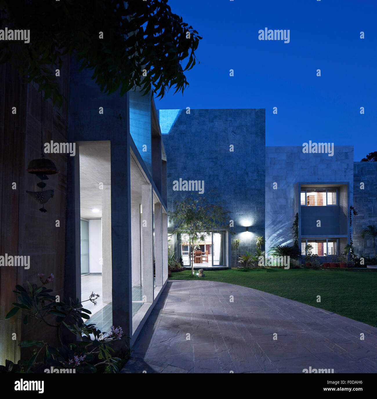 Façade avant et l'altitude avec jardin au crépuscule. Maison de marbre, Ahmedabad, Inde. Architecte : Matharoo Associates, 2015. Banque D'Images