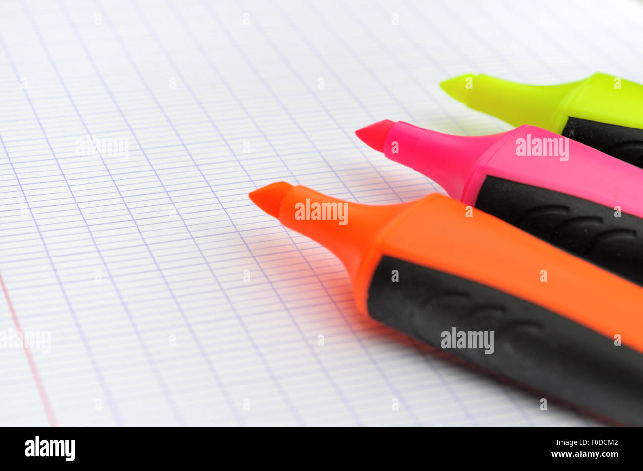 Gros plan sur trois surligneurs sans capuchon du stylo sur du papier blanc Banque D'Images