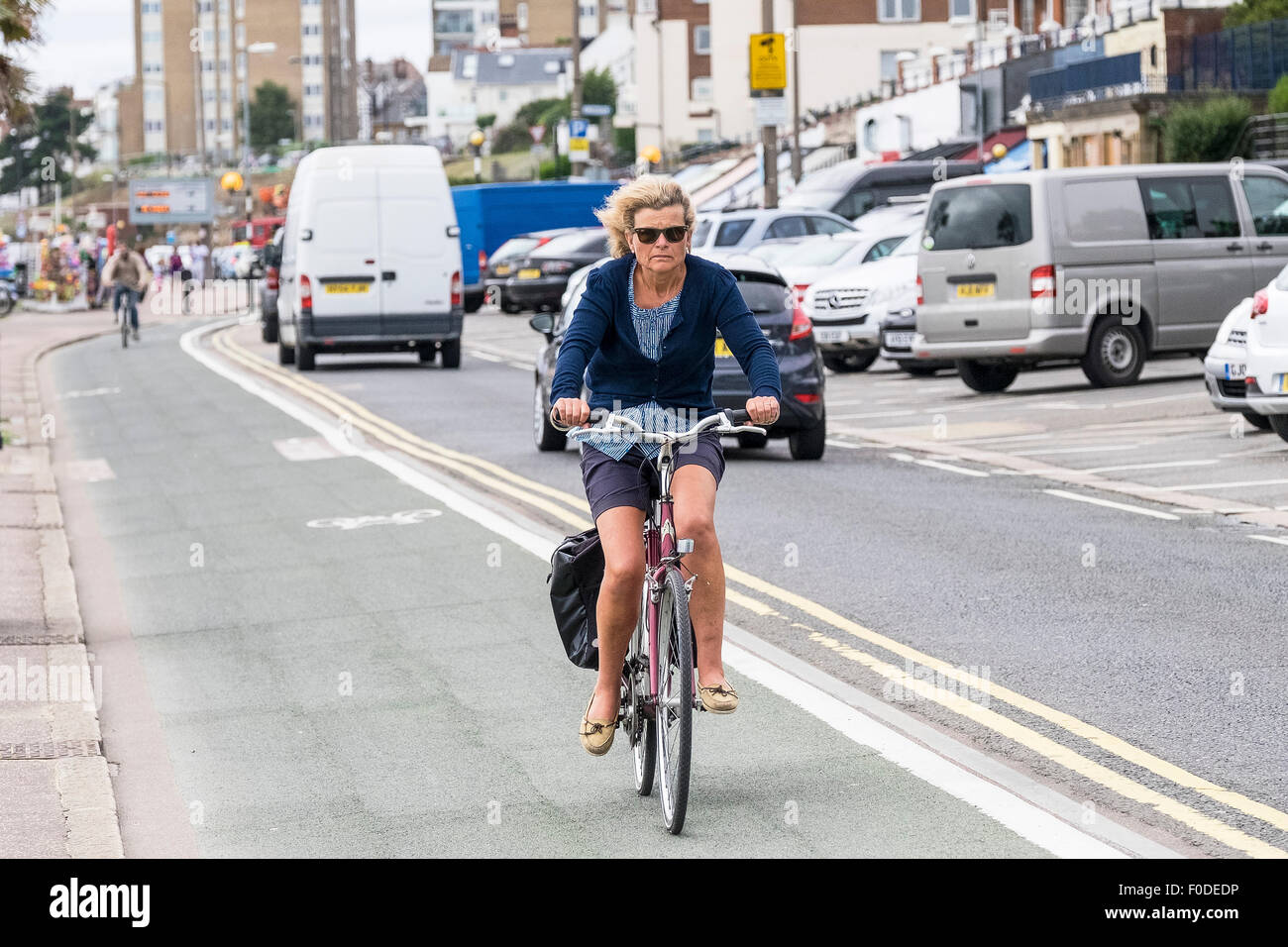Un cycliste en utilisant la voie cyclable sur front de Southend dans l'Essex. Banque D'Images