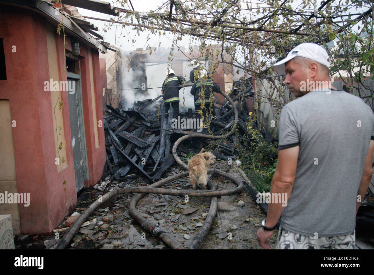 Donetsk, Ukraine. Août 13, 2015. Les pompiers éteindre un feu à un bâtiment endommagé par les bombardements dans la région de Donetsk, Ukraine, le 13 août 2015. Le cessez-le-feu dans l'Est de l'Ukraine a été violé par l'artillerie de plus en plus d'affrontements entre rebelles et troupes ukrainiennes. À la suite d'un intense bombardement, vivant plusieurs bâtiments ont été détruits à la vue de l'aéroport de Donetsk. Crédit : Alexander Ermochenko/Xinhua/Alamy Live News Banque D'Images