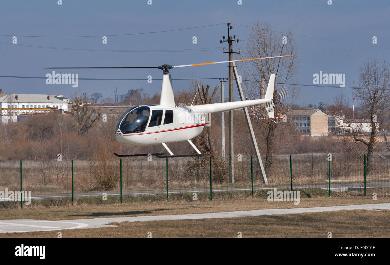 Hélicoptère Robinson R44 Raven 1 volant à basse altitude au-dessus du sol Banque D'Images