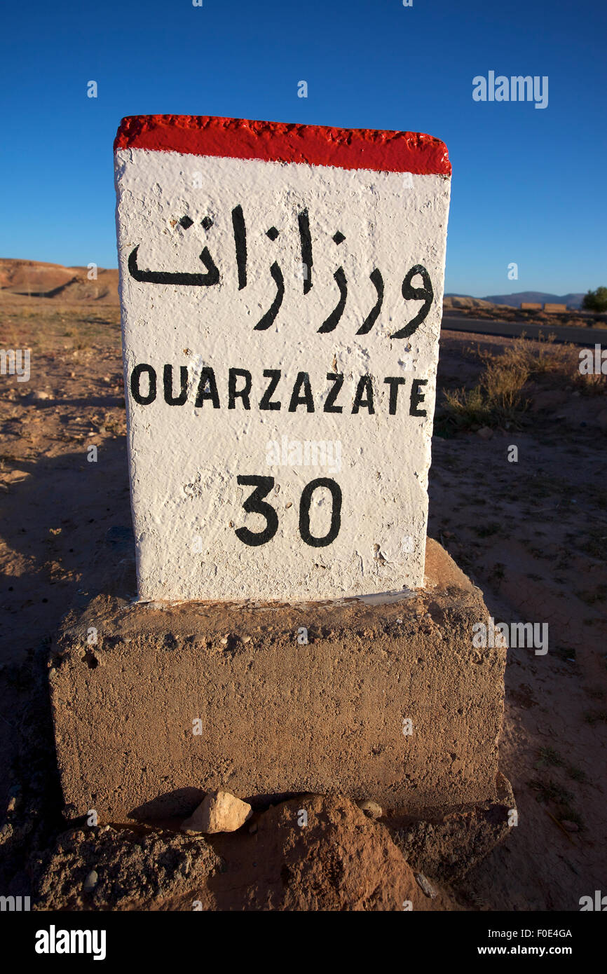 Signe de route de Ouarzazate au Maroc avec ciel bleu Banque D'Images