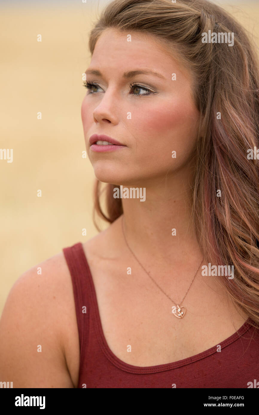 Jeune femme posant en grand champ de blé wearing red tank top. Banque D'Images
