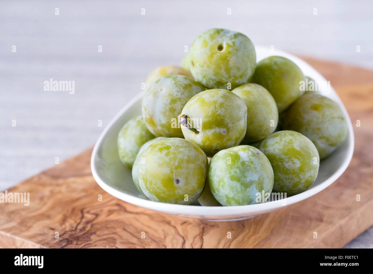 Prunus domestica. Greengages dans un bol blanc. Banque D'Images