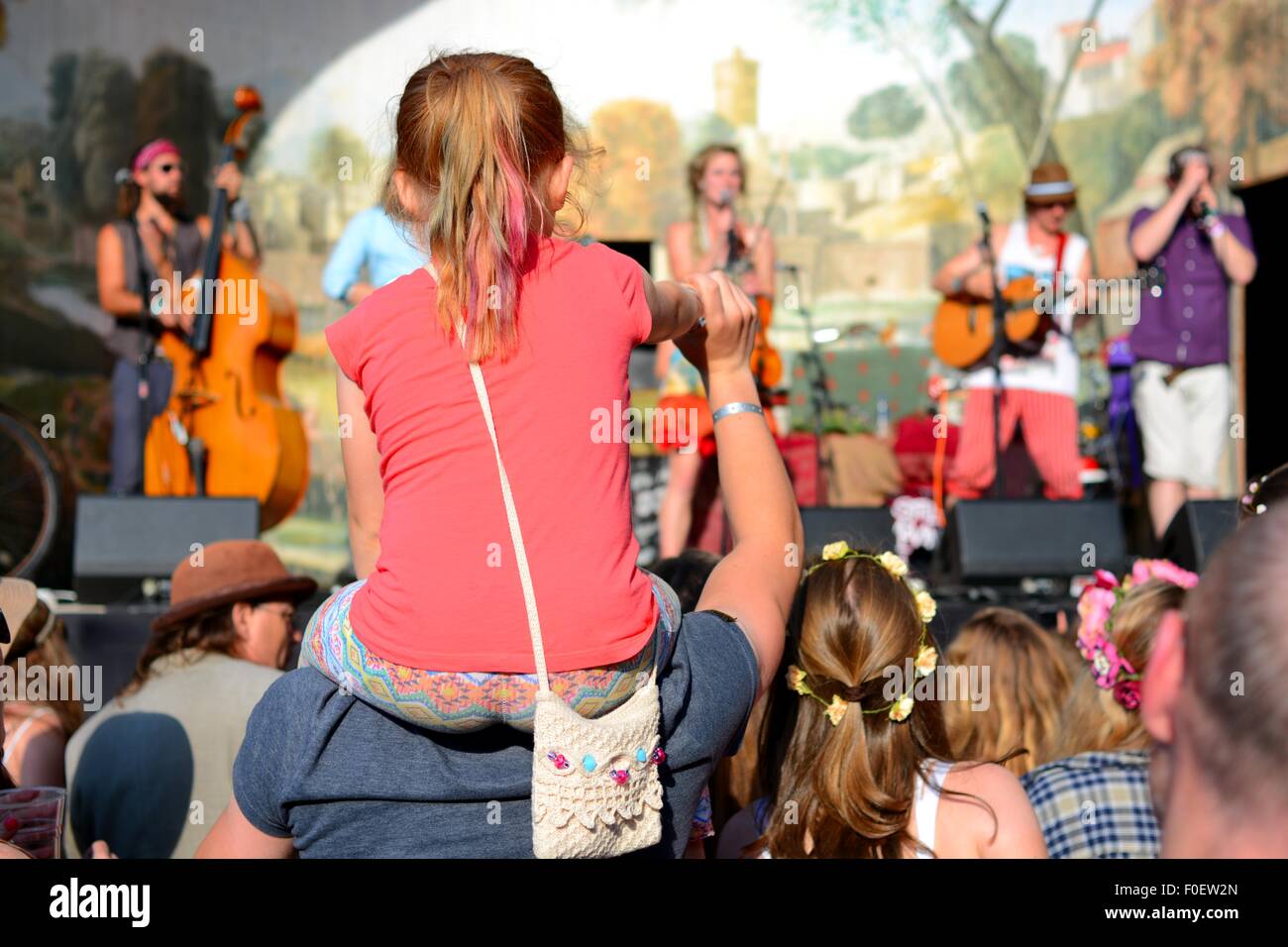 Jeune fille assise sur les épaules en regardant une bande à un festival de musique Banque D'Images