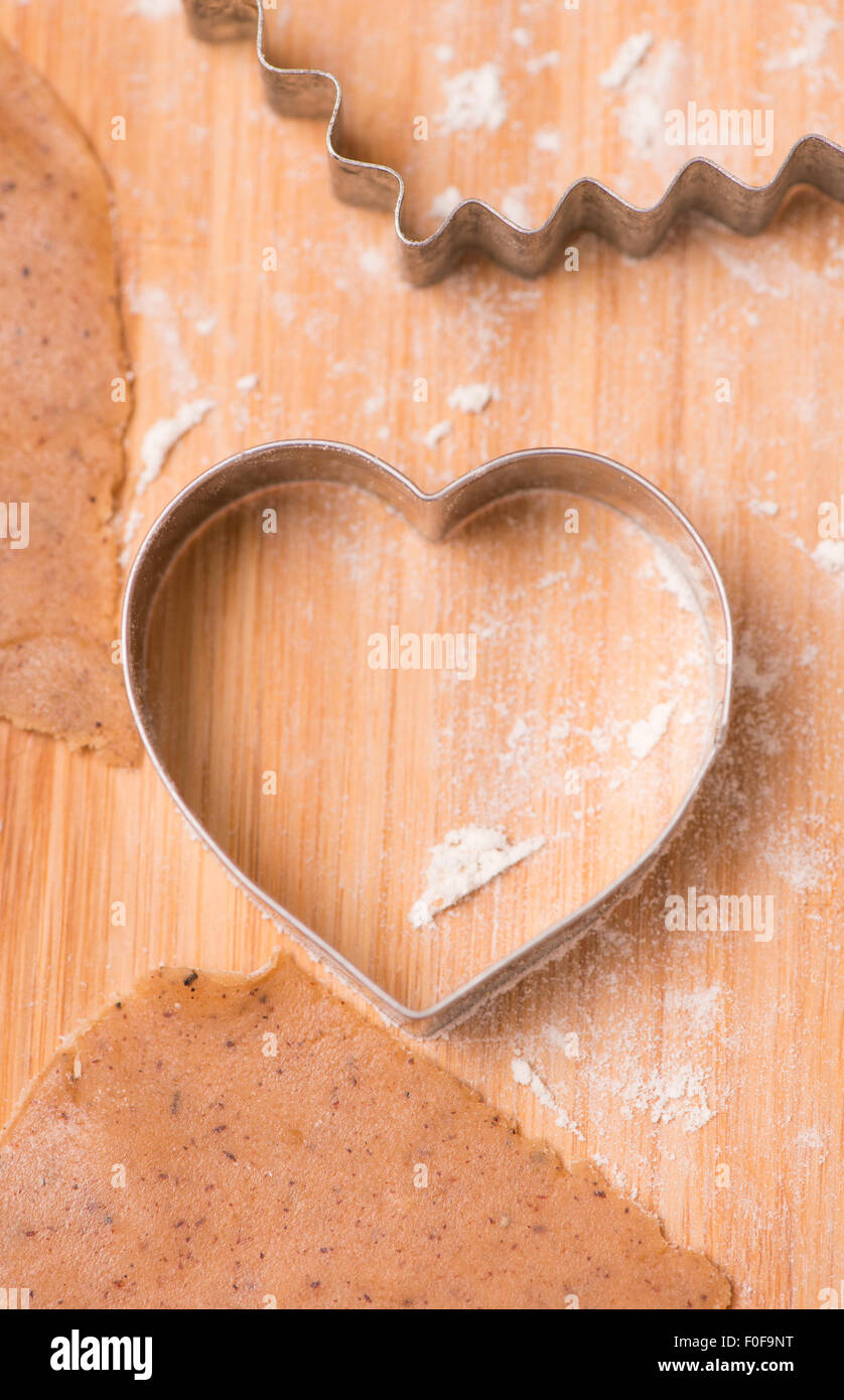 La pâte à biscuit pain d'épices et de l'emporte-pièce sur la planche à découper en bois. Banque D'Images