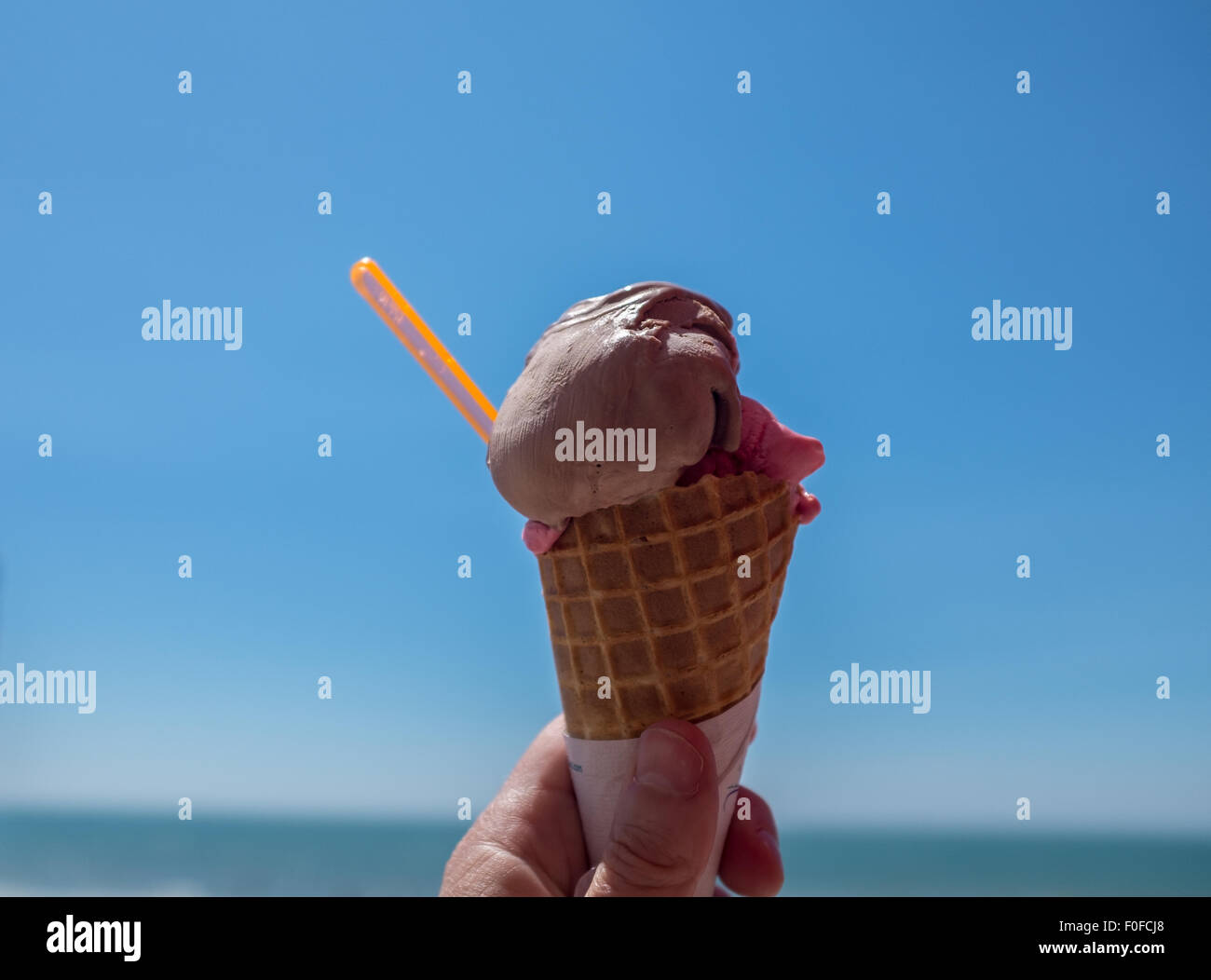 Cornet de crème glacée contre un ciel d'été bleu clair lumineux Banque D'Images