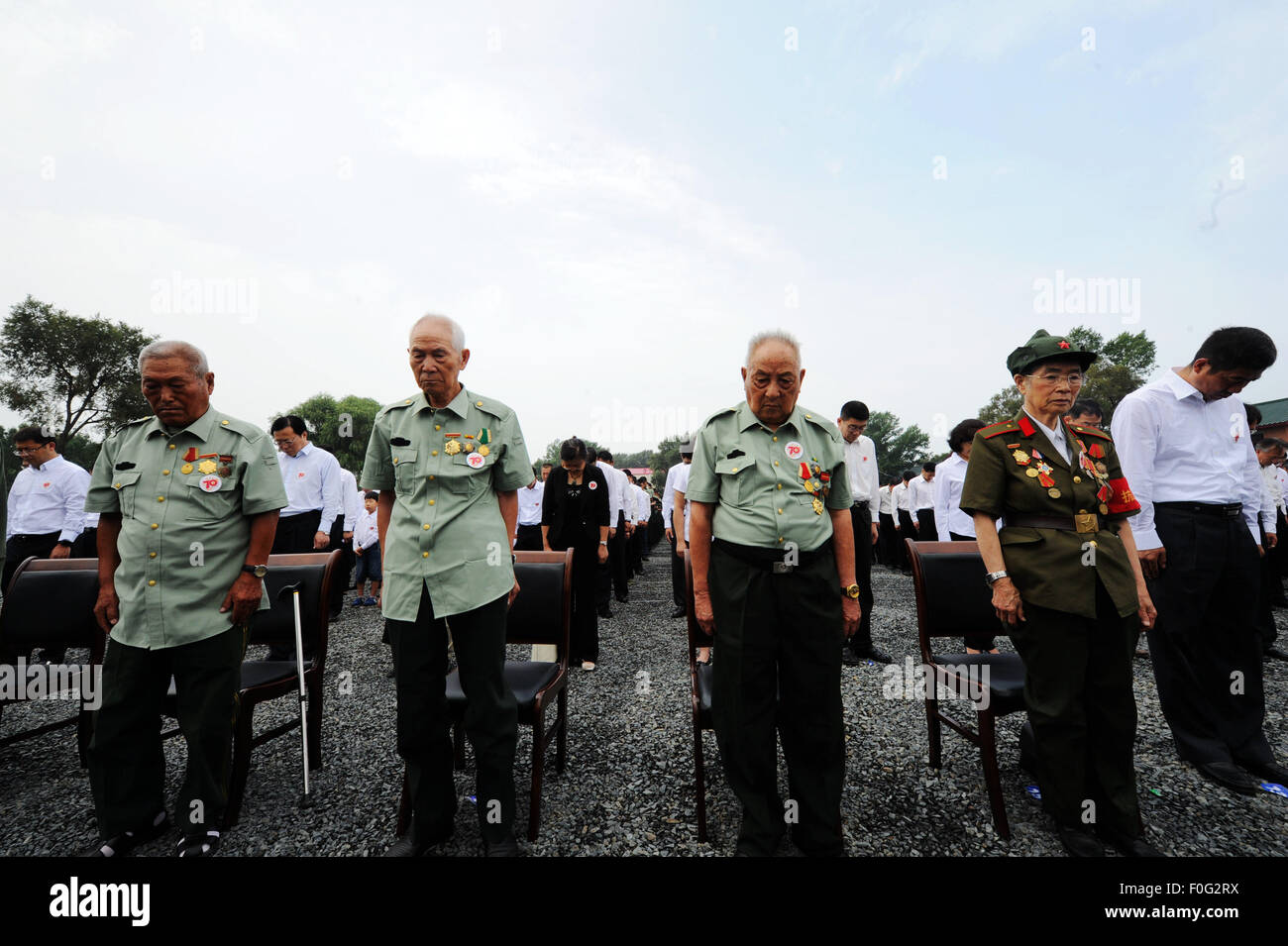 Stand des anciens combattants chinois de silence lors de la cérémonie d'ouverture d'un musée sur l'unité de l'armée japonaise pendant la guerre 731 atrocités dans Harbin, capitale de la province du nord-est de la Chine, 15 août 2015. Le Musée de preuves de crimes de guerre par l'armée japonaise l'unité 731, situé sur le site de l'ancien siège de l'unité de l'armée japonaise 731 dans Harbin, ouverte le samedi. L'unité 731 était une guerre chimique et biologique de base de recherche créé en 1935. Banque D'Images