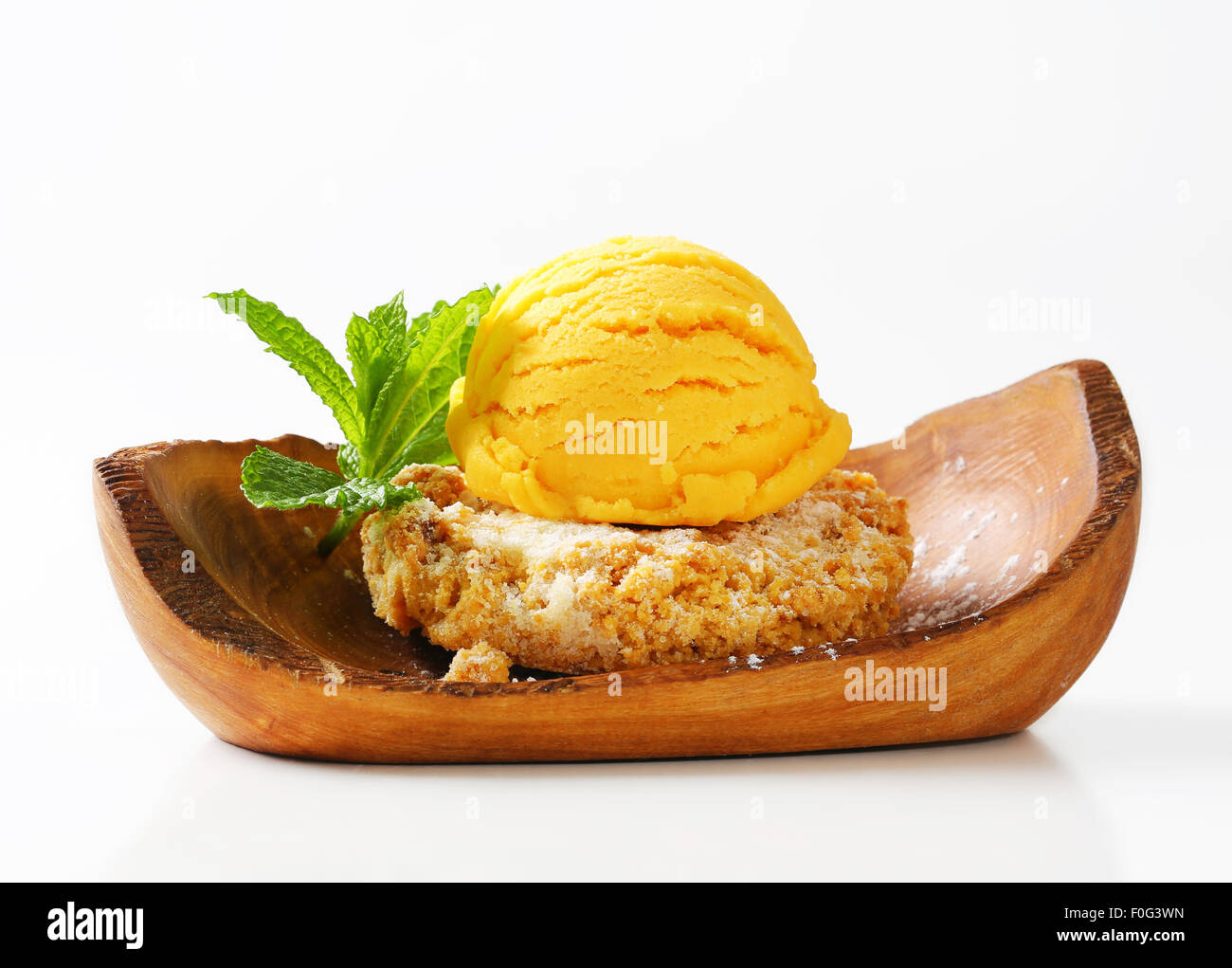 Biscuit aux amandes et boule de glace servi sur un bol en bois d'olivier Banque D'Images