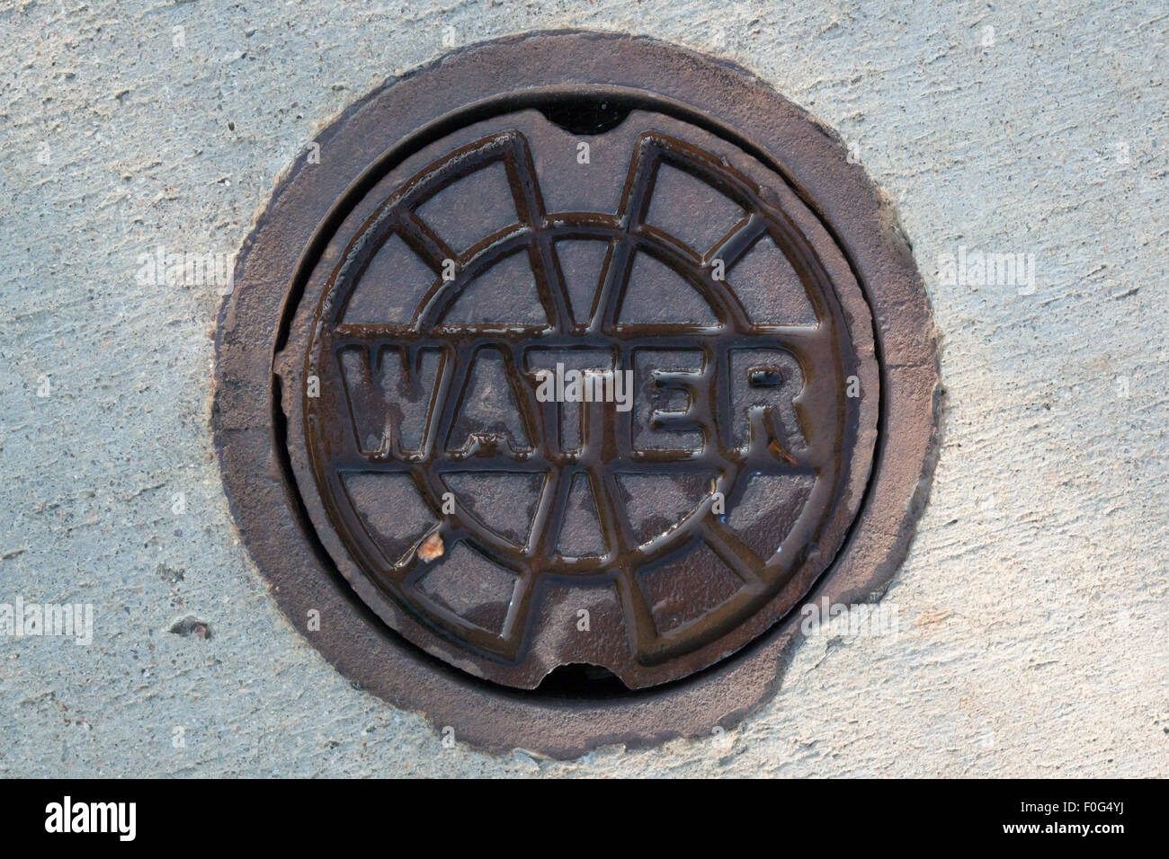 Un point d'accès pour une vanne de coupure d'une conduite d'eau principale le long d'un trottoir Banque D'Images