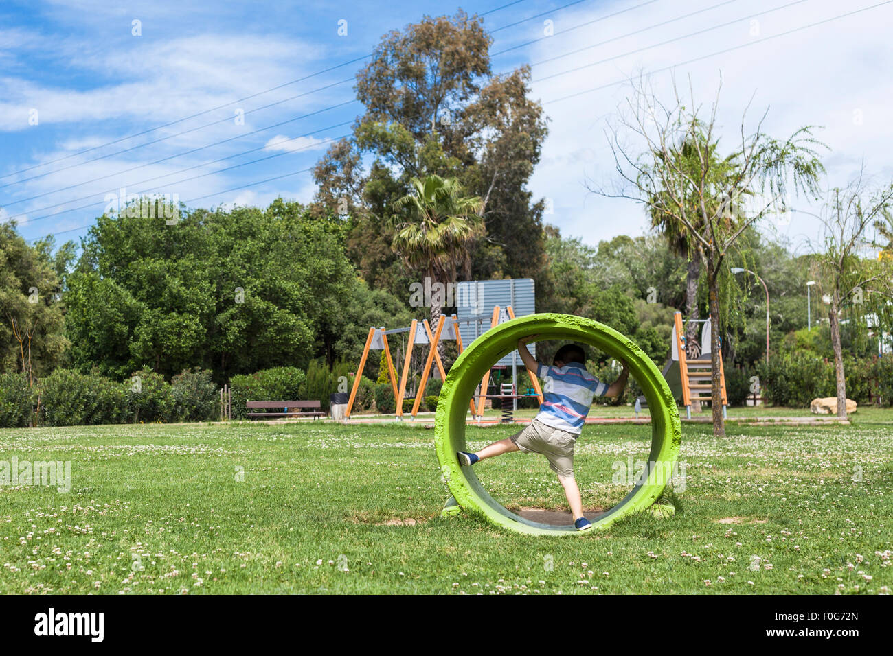 Enfant actif Garçon jouant dans le parc en journée ensoleillée. Banque D'Images