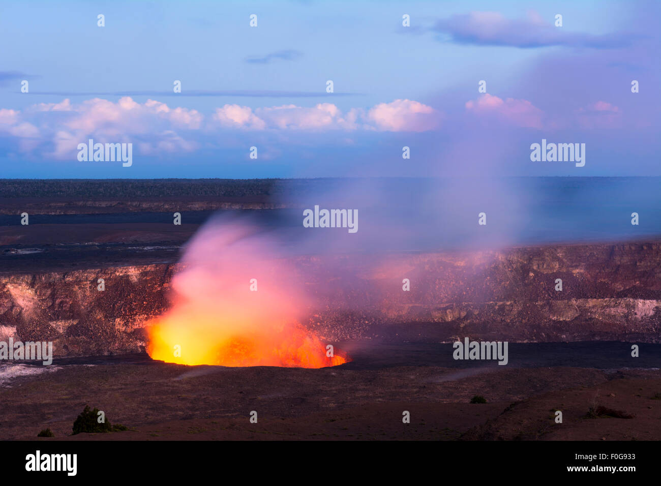 Comme le soleil se couche Kilauea volcano commence à montrer l'éclat de hot lava son évent actif, crachant des roches en fusion comme la fumée des brûlures. Banque D'Images