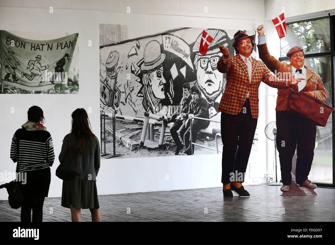 Rostock, Allemagne. Août 12, 2015. Deux femmes se tenir dans les salles d'exposition de la nouvelle pièce "ächtig Gang Olsen extenso ! Olsenbande die im Museum', à côté des chiffres de Benny et Kjeld (r) dans la galerie d'art principal à Rostock, Allemagne, 12 août 2015. L'exposition sera en montre du 16 août-22 novembre 2015. Photo : Bernd Wuestneck/dpa/Alamy Live News Banque D'Images