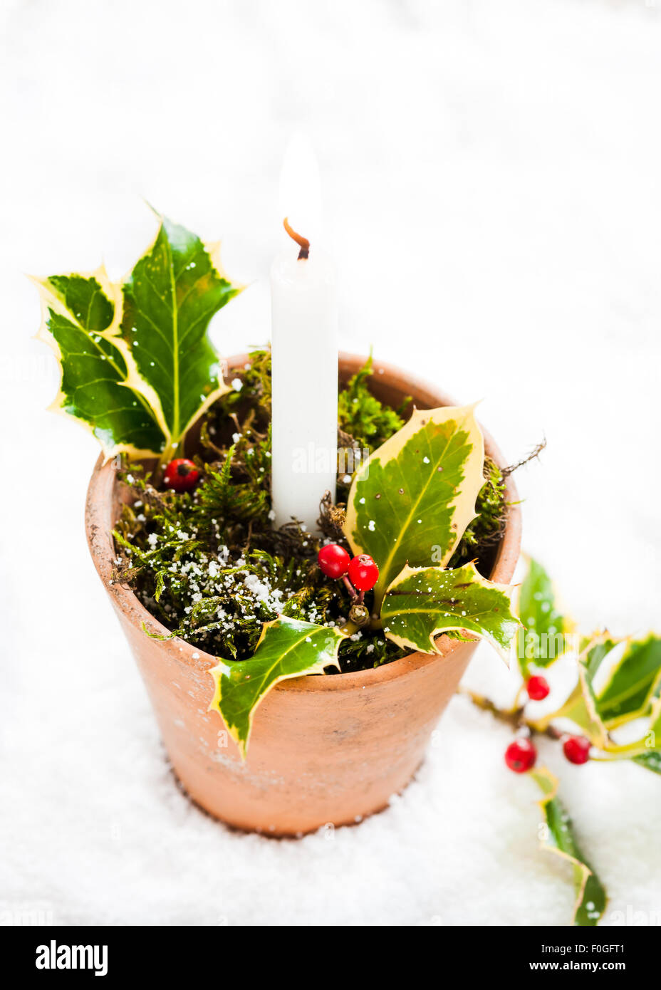 Un porte-bougie faite d'un pot en terre cuite vintage décoré de mousse et d'un ressort d'Holly Banque D'Images