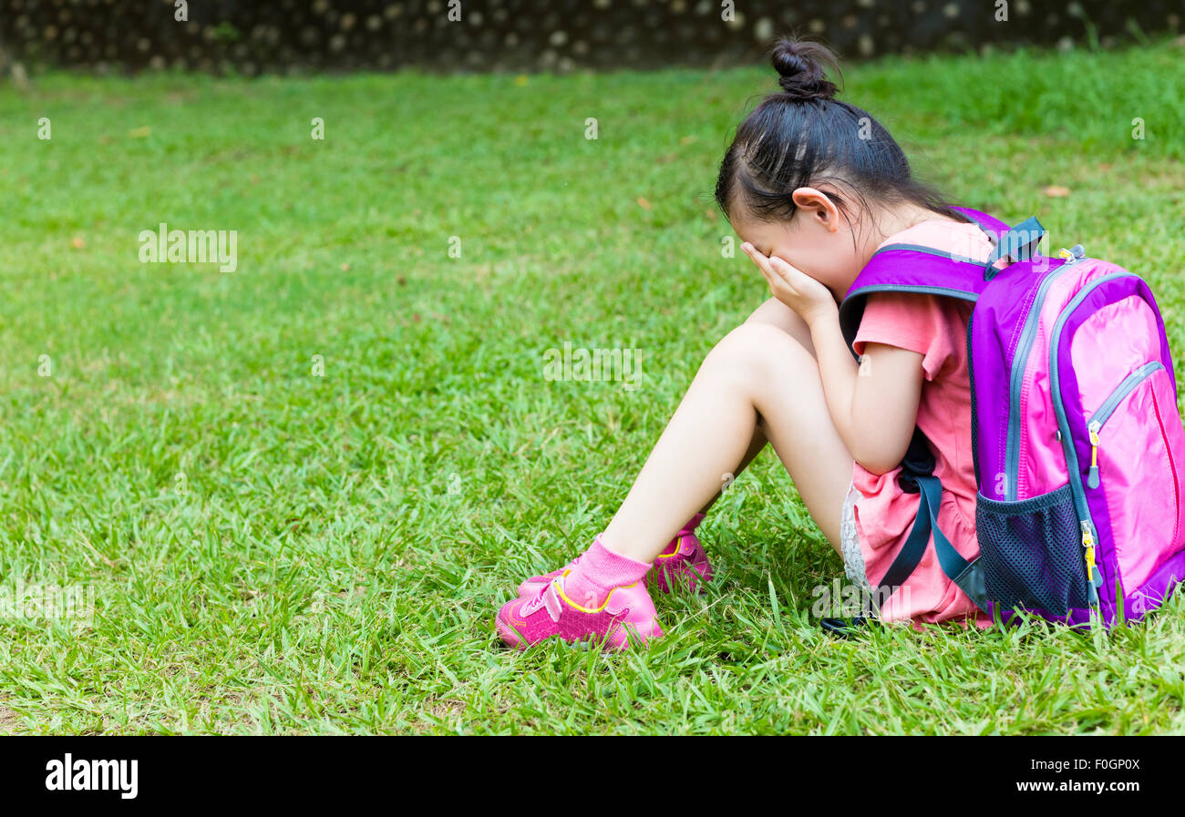Girl sitting stress et la pensée sur l'herbe Banque D'Images