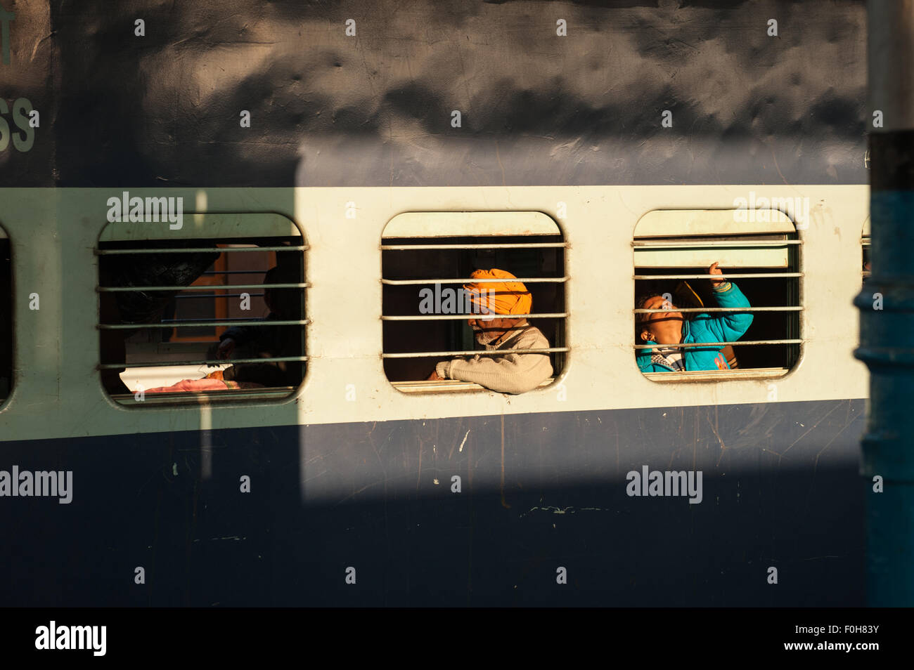 Kalka, Himachal Pradesh, Inde. Les passagers d'un train par l'intermédiaire de barreaux aux fenêtres. Banque D'Images