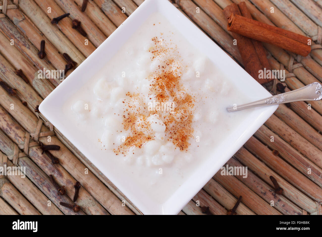 Dessert brésilien canjica de maïs blanc à la cannelle et clou de girofle en plaque blanche. Selective focus Banque D'Images