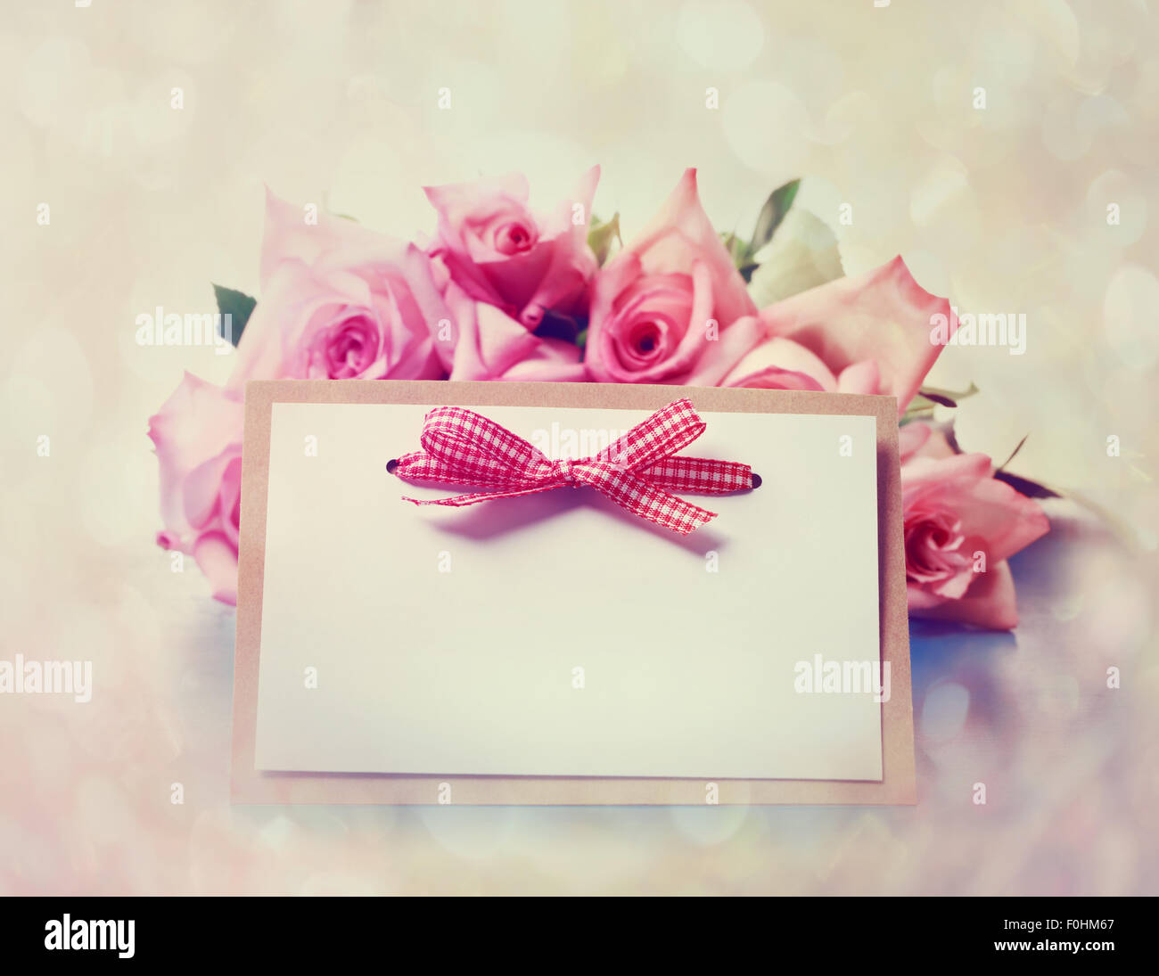 Des roses rose magnifique avec une carte message dans un style vintage Banque D'Images